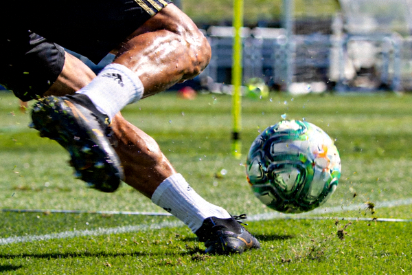 球星在训练场上进行高强度射门练习的特写镜头